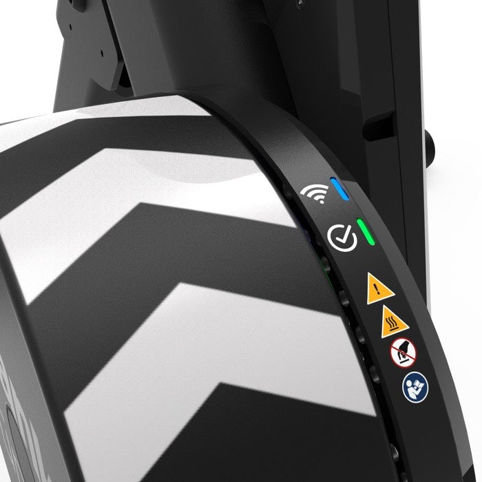 Close-up of the Wahoo KICKR CORE 2 with Zwift Cog and Click smart trainer housing showing WiFi and status indicator lights, safety symbols and operating instructions