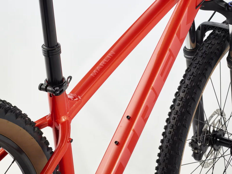 Close-up of a red bicycle frame with visible branding on a white background