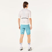 Person wearing a white cycling jersey and light blue shorts on a white background