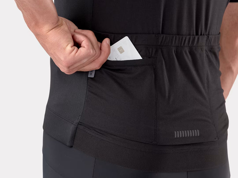 Person wearing black pants with a pocket, holding a card.