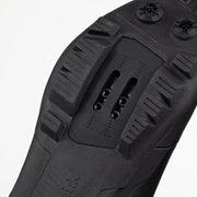 Close-up of a black shoe sole with tread pattern on a white background