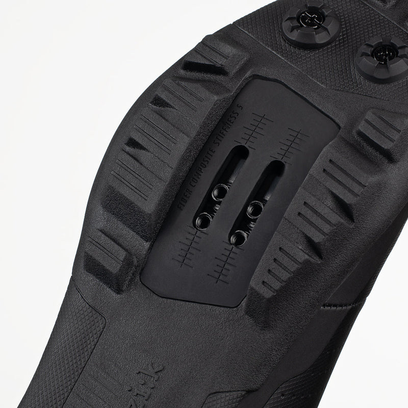 Close-up of a black shoe sole with tread pattern on a white background