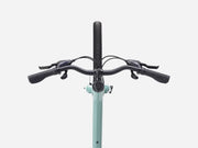 Bicycle handlebar with black grips and controls on a light blue frame against a white background