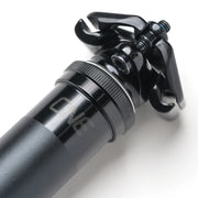 Close-up of a black bicycle shock absorber with 'ONE' branding on a white background