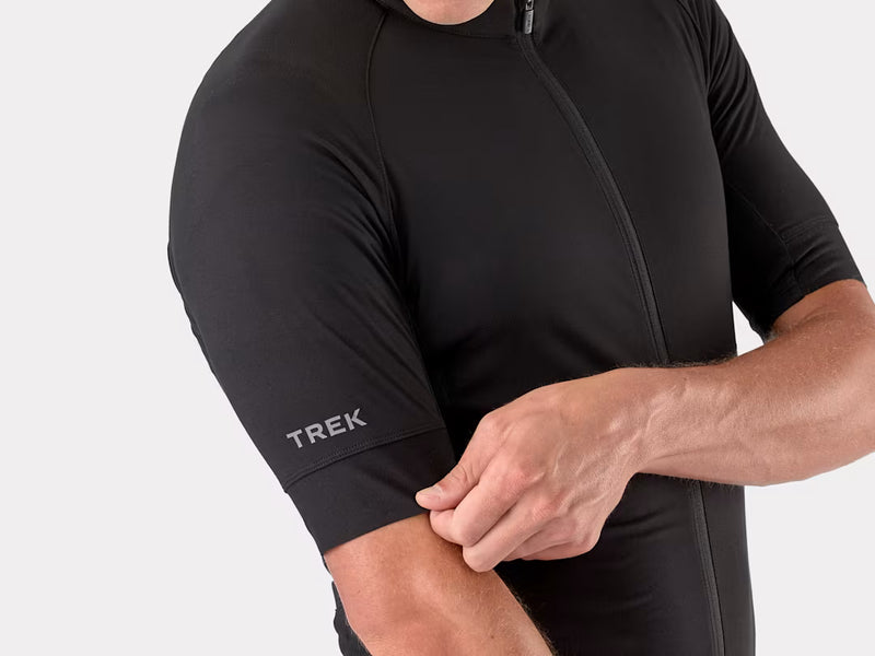 Black cycling jersey with 'Trek' logo on a gray background