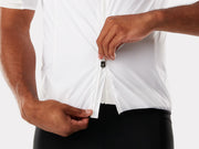 Person wearing a white cycling jersey with a close-up of the zipper.