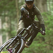 Person riding a mountain bike through a forest