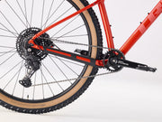 Close-up of a red bicycle wheel and gear system on a white background