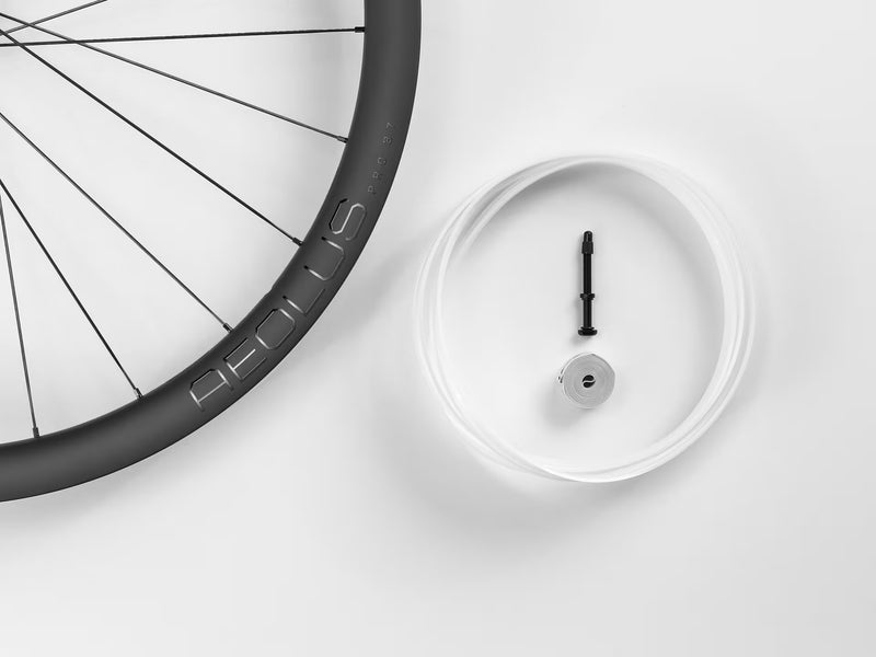 Bicycle wheel and a small round device on a white background