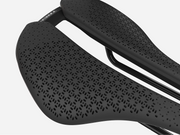 Close-up of a black bicycle saddle with perforated design on a white background