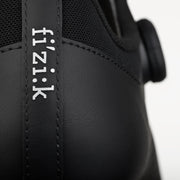 Close-up of a black cycling shoe with 'fi'zi:k' branding on a white background