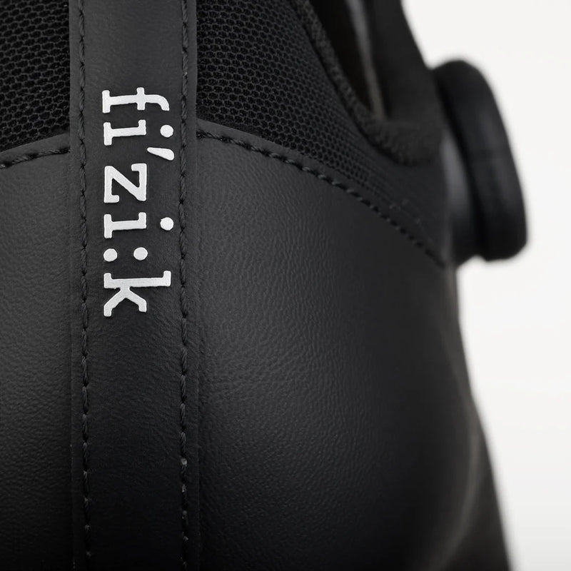 Close-up of a black cycling shoe with 'fi'zi:k' branding on a white background