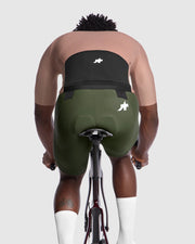 Person wearing green cycling shorts with a visible brand logo on a white background