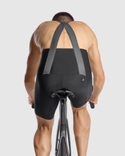 Person wearing black cycling bib shorts on a white background