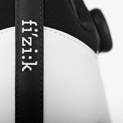 Close-up of a black and white cycling shoe with 'fizik' branding.