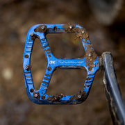 Blue bicycle pedal with 'ONE' branding on a blurred background