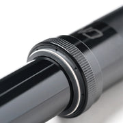 Close-up of a metallic cylindrical object with a textured ring on a white background