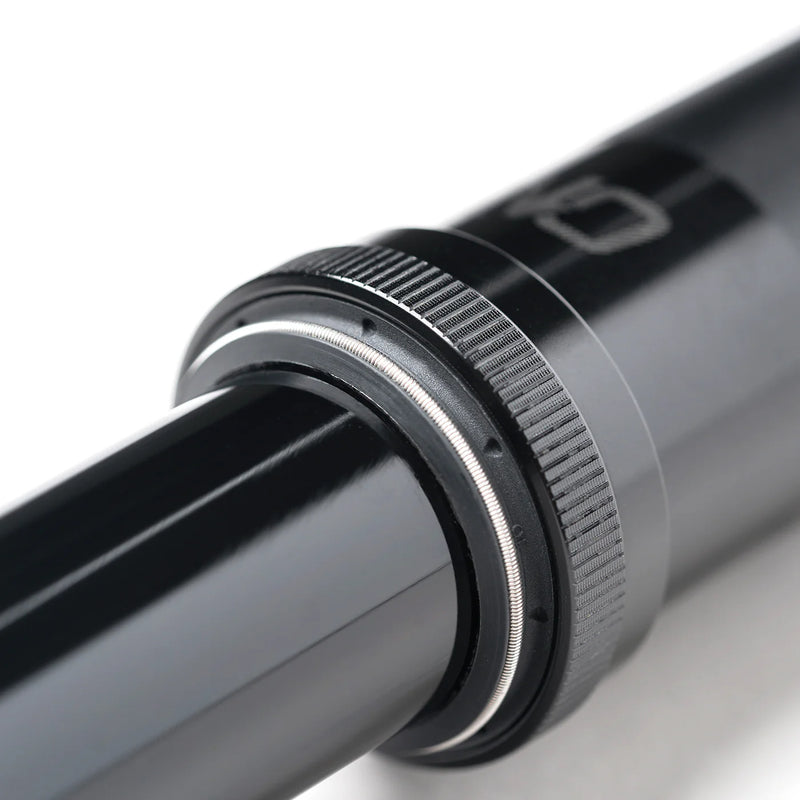 Close-up of a metallic cylindrical object with a textured ring on a white background