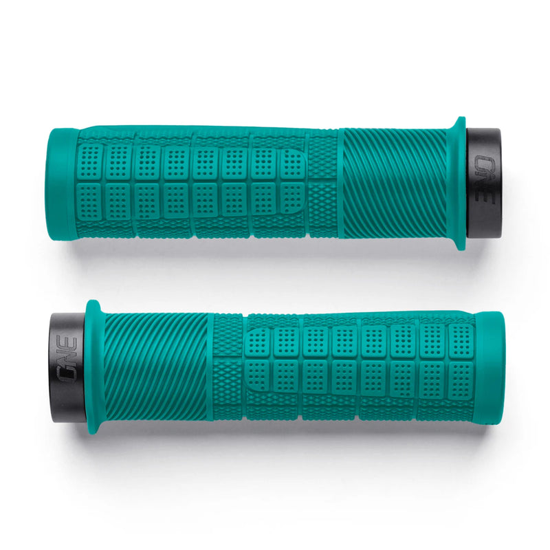 Two teal bicycle grips with black ends on a white background