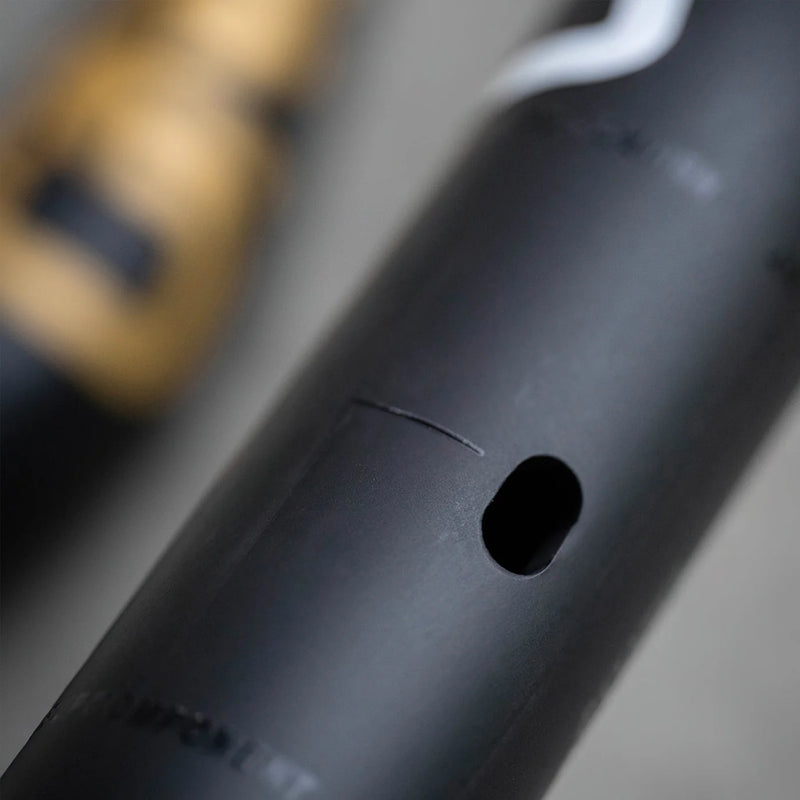 Close-up of a black cylindrical object with a small hole on a blurred background