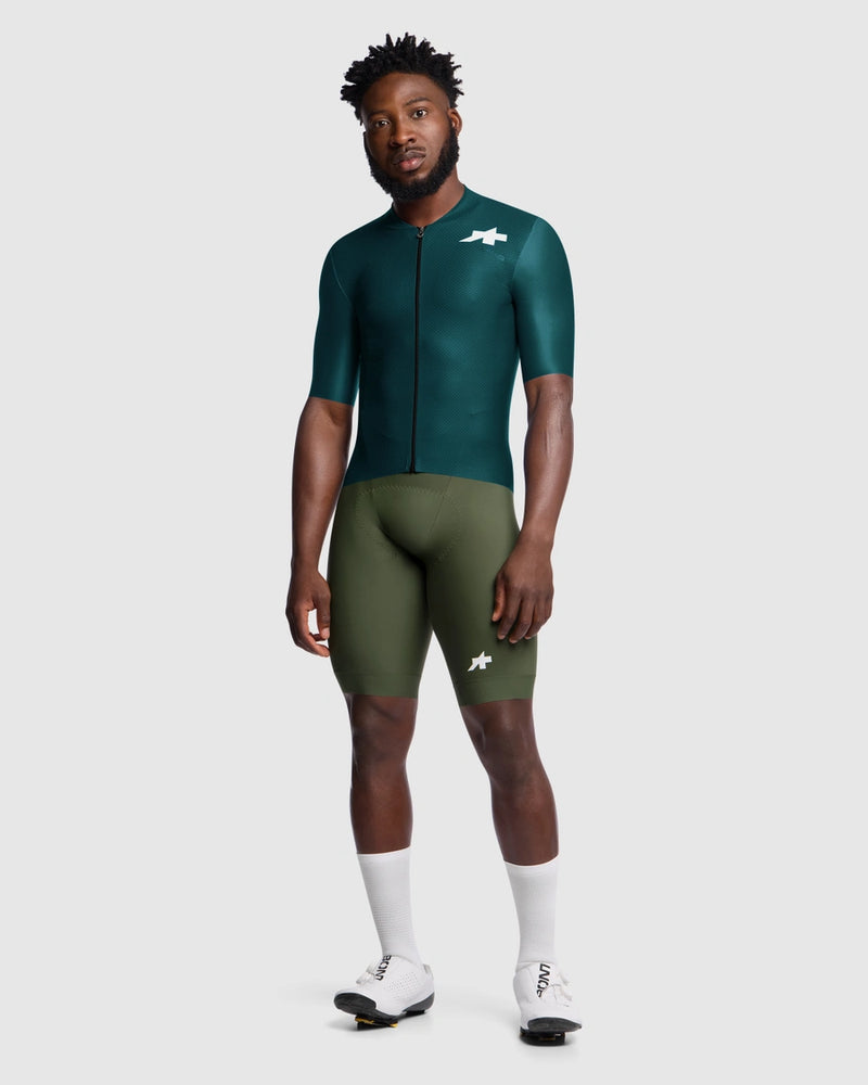 Person wearing a green cycling outfit with a white background