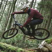 Person riding a mountain bike through a forest