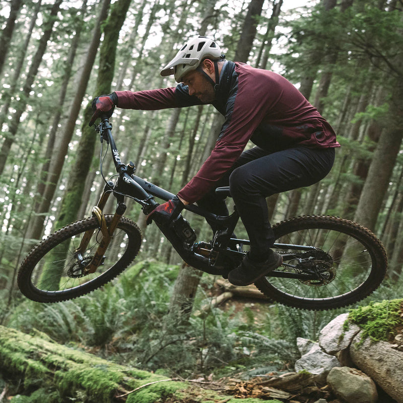 Person riding a mountain bike through a forest