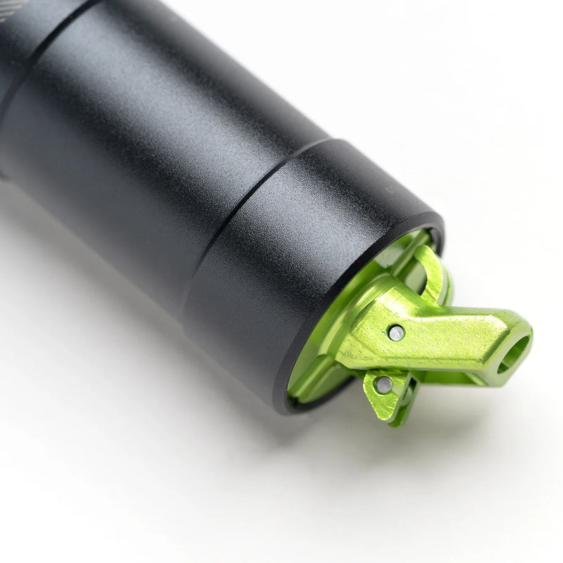 Black cylindrical object with a green metallic component on a white background