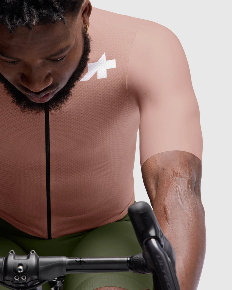 Person wearing a sleeveless cycling jersey with a logo on a white background