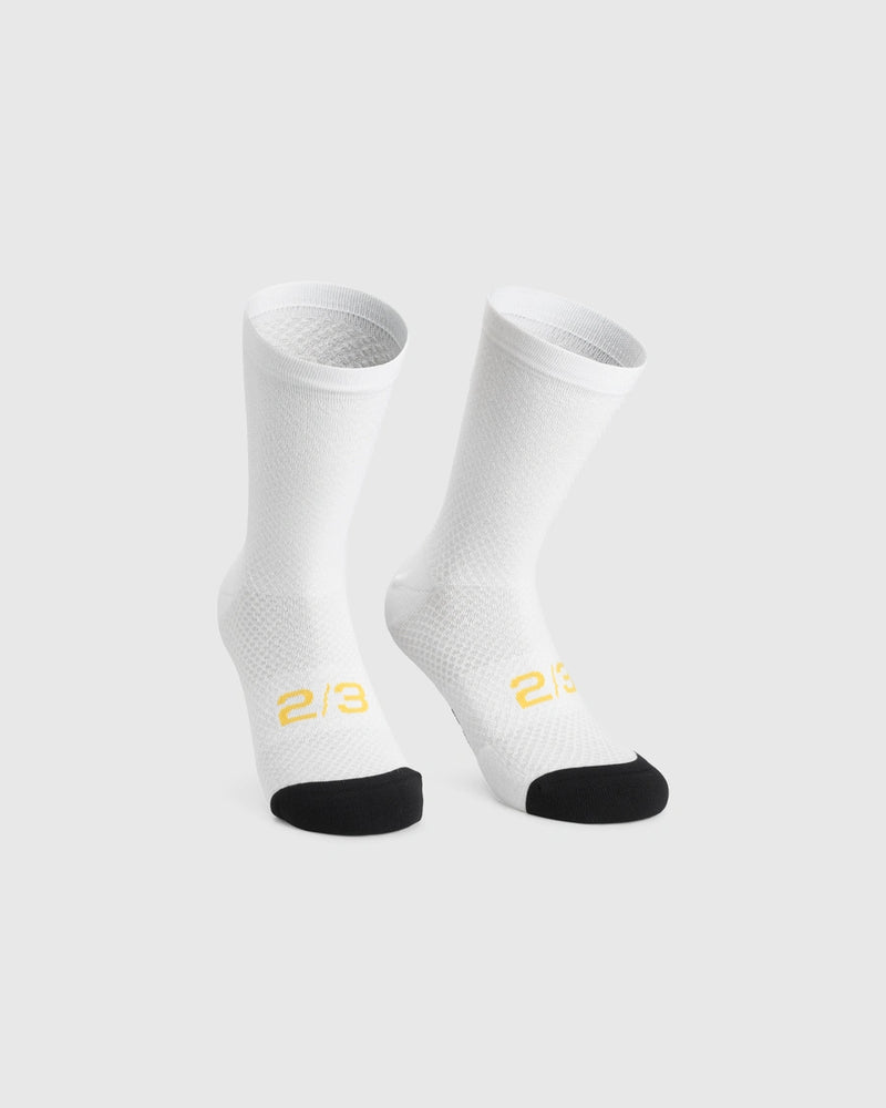 Assos Spring Fall Socks P3 cycling socks in White Series colourway, front view showing breathable knit construction, black reinforced toe panel, 18 cm cuff height, and yellow 2/3 graphic detailing.