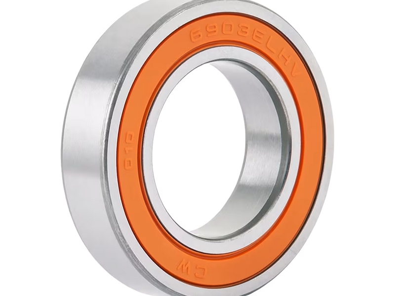 Metallic bearing with orange inner ring on a white background; a bearing