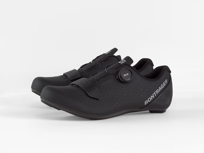 Three-quarter view of paired black Bontrager Circuit road cycling shoes showcasing the lateral BOA dial and strap layout on one shoe alongside the medial profile of the other