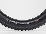Close-up of a Gnarwhal bike tire on a white background