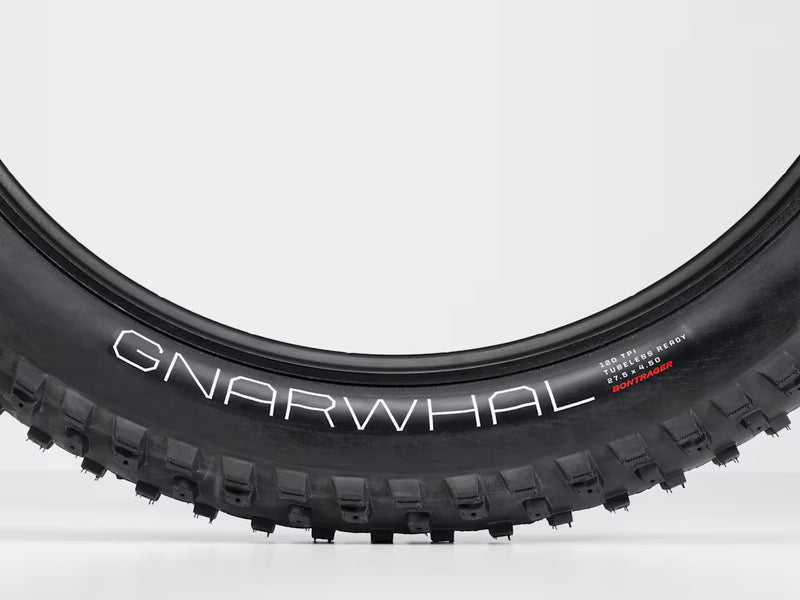 Close-up of a Gnarwhal bike tire on a white background