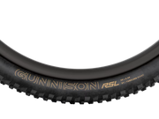 Close-up of a black bicycle tire with visible branding on a white background