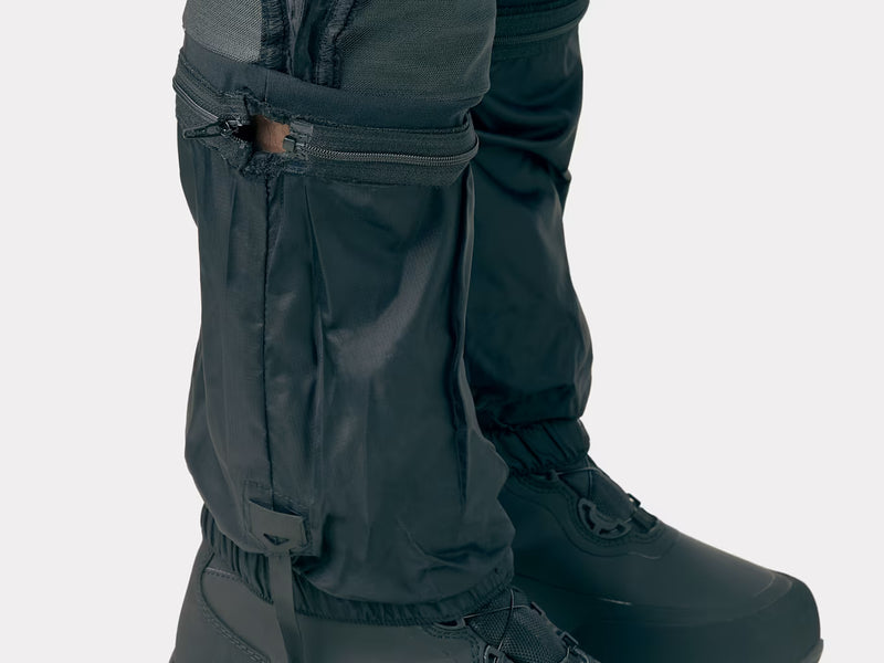 Bontrager OMW softshell pant in black worn, close-up of lower legs with internal gaiter and snow boots
