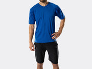 Front studio view of male model wearing a blue t-shirt and black Bontrager Quantum fitness shorts, displaying the relaxed fit and casual silhouette