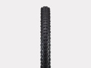 Black tire with tread pattern on a light gray background