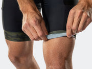 Close-up of the green camo leg cuff on the Bontrager Troslo inForm Cycling Liner Short being rolled to show the stretch, with pocket stitching and mesh vent