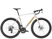 A Trek road bicycle with a cream-colored frame, black drop handlebars, black wheels, and gold Trek branding, shown against a solid white background.