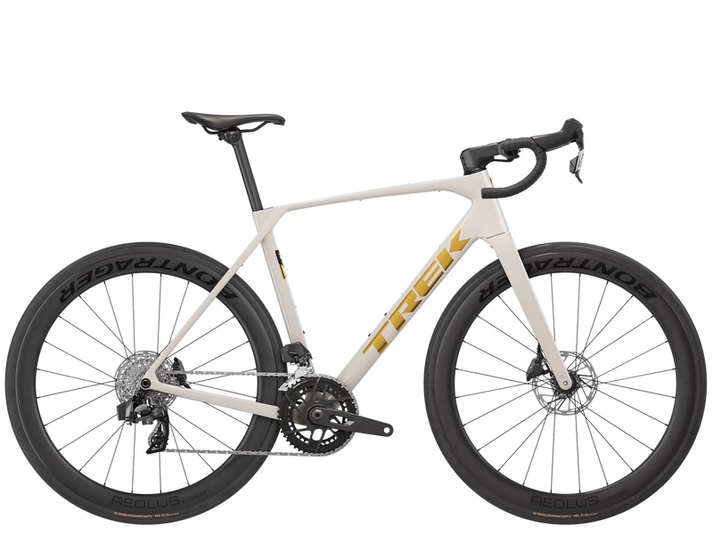 A Trek road bicycle with a cream-colored frame, black drop handlebars, black wheels, and gold Trek branding, shown against a solid white background.