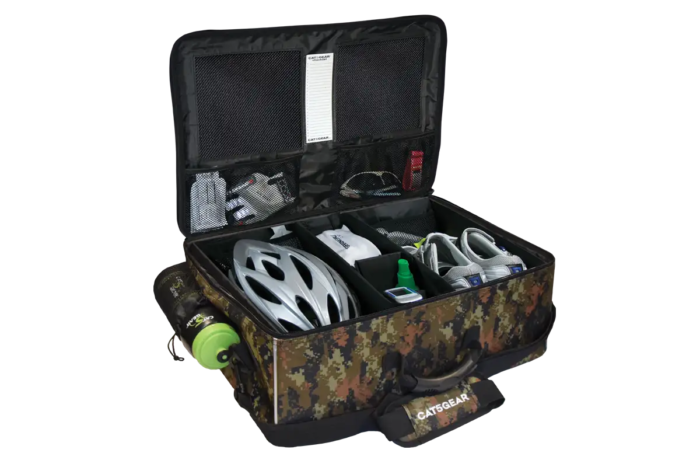 An open CAT5GEAR bicycle BAG with a camouflage pattern exterior, black interior lining, and various CYCLING items organized inside, including a white bicycle helmet, a green bottle, shoes, gloves, shown on a white background.