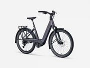 A dark gray step-through electric bicycle with a rear cargo rack, fenders, and a battery integrated into the frame, shown against a plain light gray background.