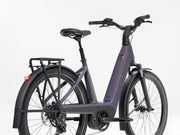 A step-through electric bicycle in a dark purple and black colorway, shown from a three-quarters rear angle against a clean white background.