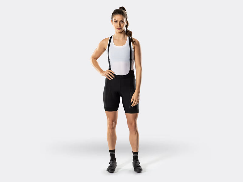 Bontrager Circuit women's black cycling bib shorts full-body view on model, featuring a flattering athletic silhouette, supportive bib construction, compression-fit shorts, and premium comfort for everyday cycling and endurance rides.
