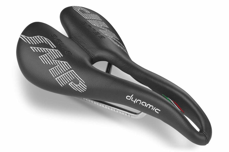 Selle SMP Dynamic Saddle in black with white stitched logos and central ergonomic cutout, shown at a front diagonal angle.