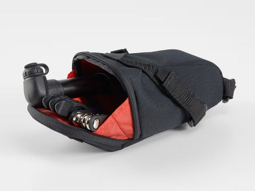 Black bag with red interior containing a black and silver tool on a white background