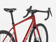 Red endurance road bicycle with black components on a white background