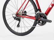 Close-up of a red bicycle's rear wheel and gear system on a white background