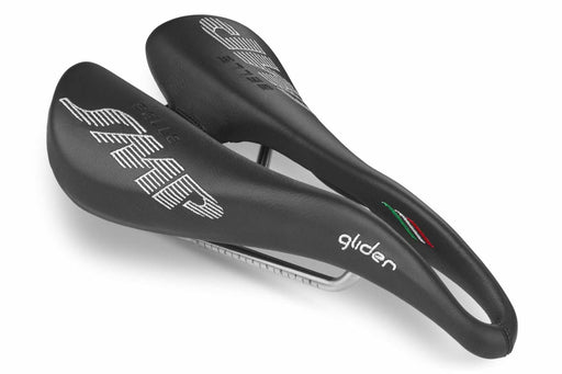 Selle SMP Glider Saddle in black with white stitched logos and central ergonomic cutout, shown at a front diagonal angle.